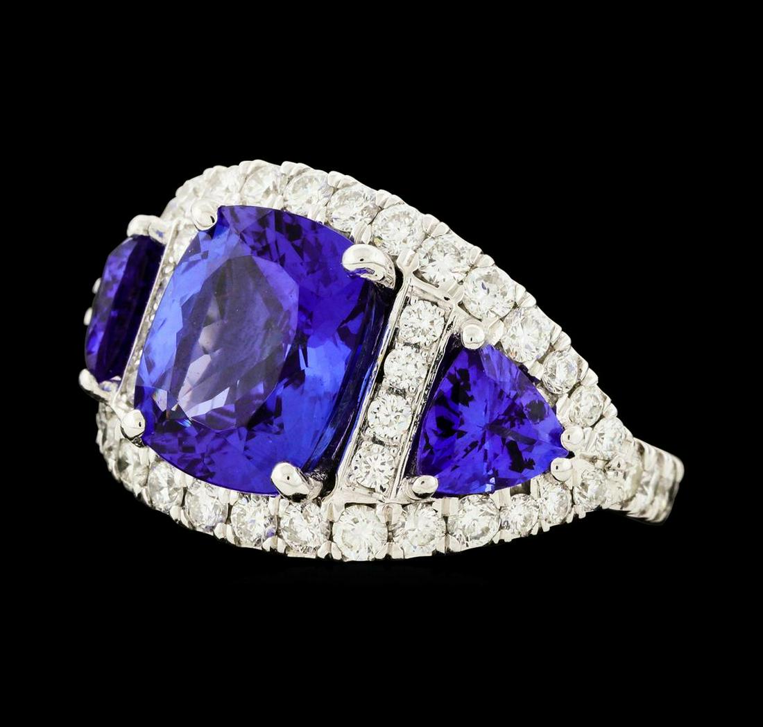 6.10 ctw Tanzanite and Diamond Ring - 14KT White Gold: One electronically tested 14KT white gold lady's cast 3-stone halo ring with a diamond eternity shank with a bright polish finish. The featured lady's ring has a shank measuring 2.80 millimeters wide.