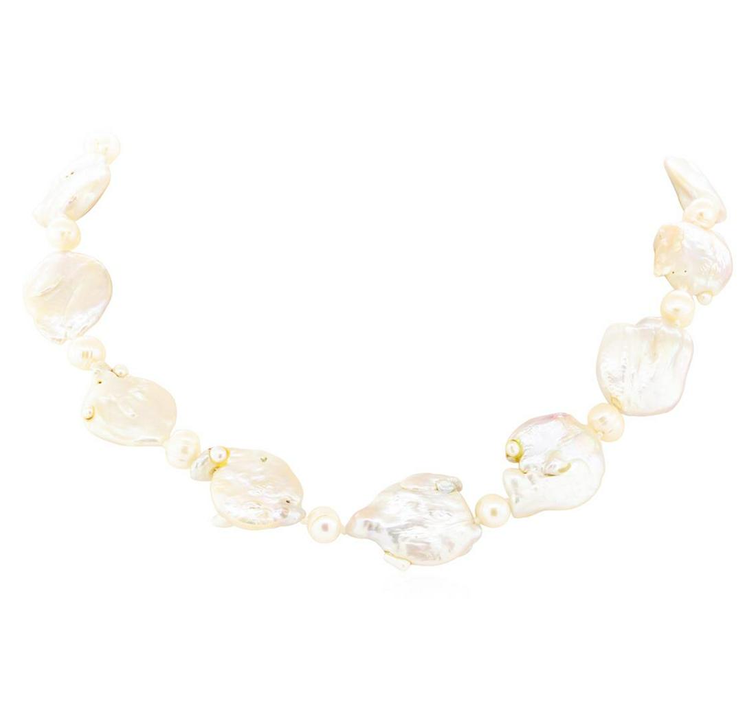 Baroque Coin Pearl Necklace - 18KT Yellow Gold: One baroque coin pearl necklace measuring twenty inches in length featuring: 18KT yellow gold weighing 10 grams with a total weight of 92.8 grams.