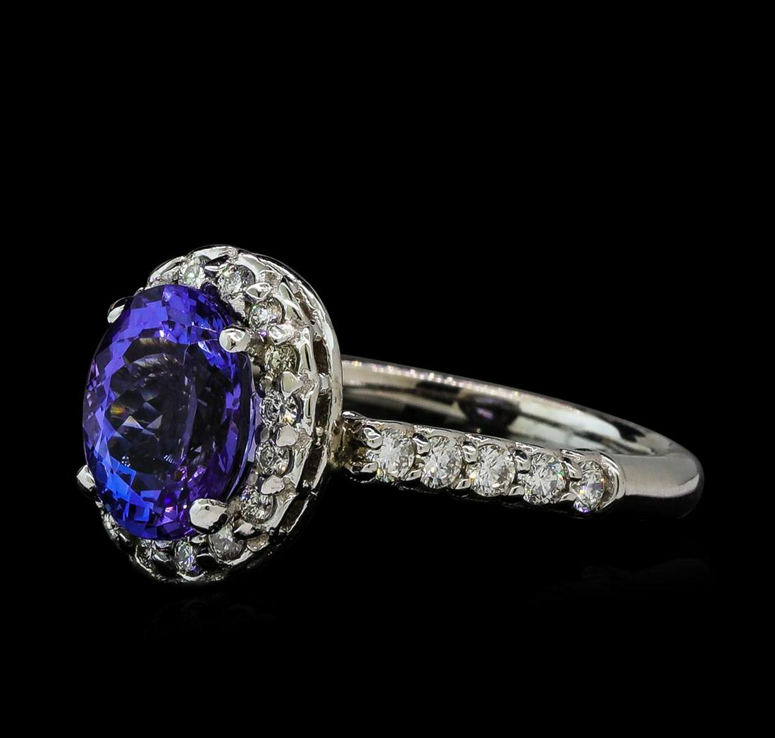 2.71 ctw Tanzanite and Diamond Ring - 14KT White Gold: One electronically tested 14KT white gold ladies cast & assembled tanzanite and diamond ring with a bright polish finish. The featured tanzanite is set within a diamond bezel supported by a diamond ac