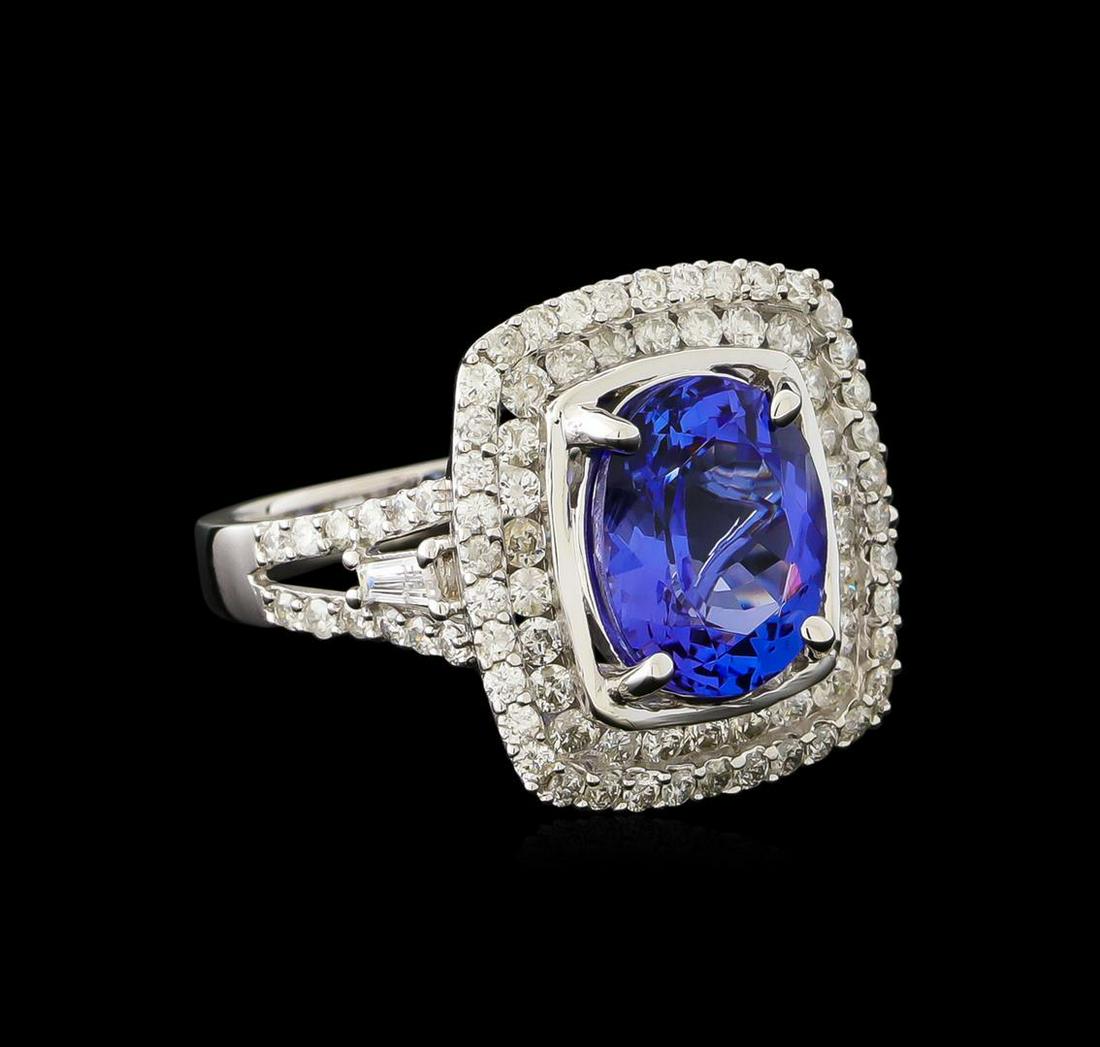 3.96 ctw Tanzanite and Diamond Ring - 14KT White Gold: One electronically tested 14KT white gold ladies cast tanzanite and diamond ring with a bright polish finish. The featured tanzanite is set within tiered diamond bezels supported by diamond set split 