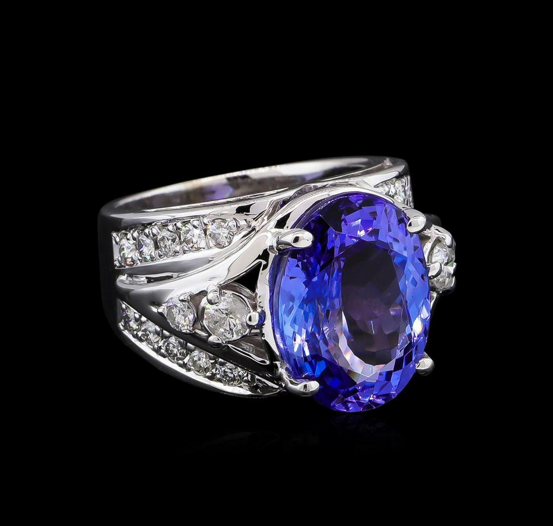 8.75 ctw Tanzanite and Diamond Ring - 14KT White Gold: One electronically tested 14KT white gold lady's cast fashion ring with a tapered cathedral shank with a bright polish finish. The featured lady's ring has a shank measuring 4.49 millimeters wide. Con