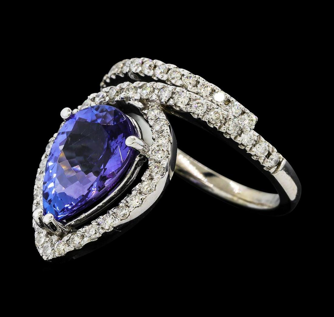 3.94 ctw Tanzanite and Diamond Ring - 14KT White Gold: One electronically tested 14KT white gold lady's cast fashion ring with a offset halo with a bright polish finish. The featured lady's ring has a shank measuring 2.03 millimeters wide. Identified with