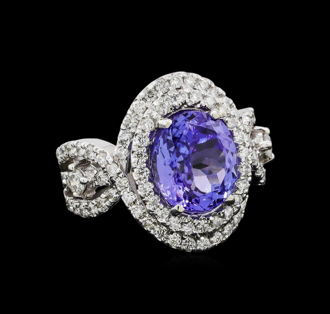 4.45 ctw Tanzanite and Diamond Ring - 14KT White Gold: One electronically tested 14KT white gold lady's combination cast & assembled fashion ring with a crossover shank double halo with a bright polish finish. The featured lady's ring has a shank measurin