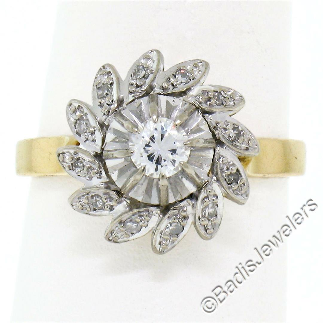 Vintage 18kt White and Yellow Gold Diamond Swirl Flower: A vintage 18kt yellow and white gold flower cluster ring with a 0.20ct round transitional cut diamond (E - VVS2) solitaire surrounded by 0.18ctw of round single cut diamonds (F/G - VS2). The ring is s