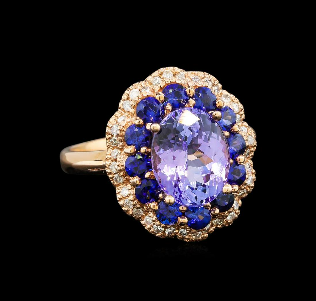 14KT Rose Gold 2.90 ctw Tanzanite, Sapphire and Diamond: One electronically tested 14KT rose gold ladies cast tanzanite, sapphire and diamond ring with a bright polish finish. Identified with markings of "K14". Condition is new. Containing: One prong set ov