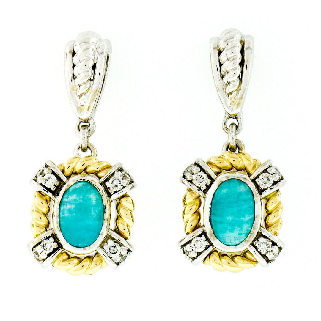 14kt Two Tone Gold Oval Amazonite & 0.16 ctw Diamond: A pair of 14kt white and yellow gold dangle earrings featuring a pair of bezel set natural amazonites (6.0x3.8mm) and 16 round brilliant diamonds (G/H - VS1/VS2; 0.16ctw). The earrings measure approxi