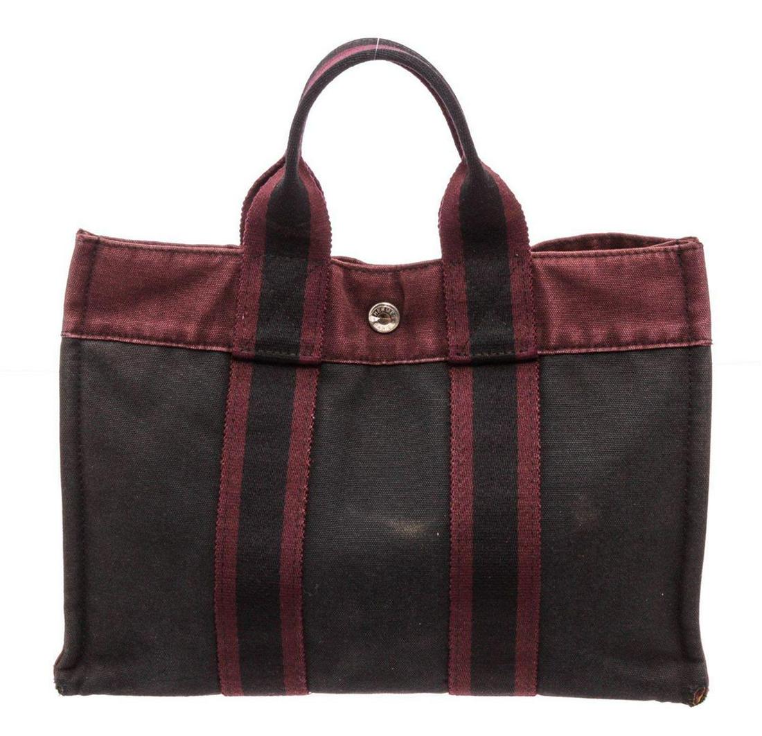 Hermes Burgundy Black Canvas PM Tote Bag: Hermes Burgundy Black Canvas PM Tote Bag. Hermes Burgundy Black Canvas PM Tote Bag with silver-tone hardware, dual rolled top handles, snap expansions at sides, tonal Toile Officier interior, single z