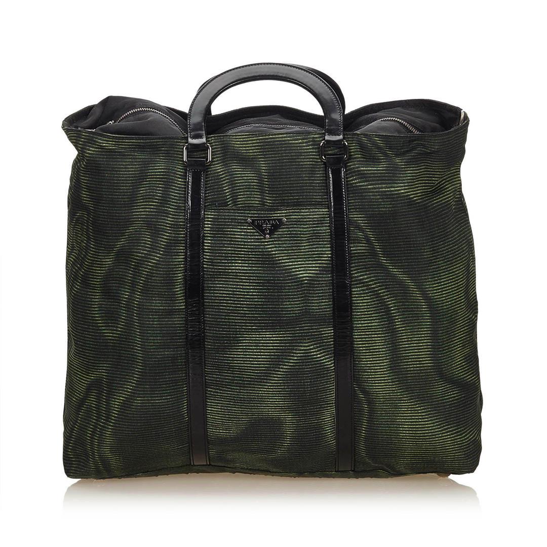 Prada Nylon Handbag: Prada nylon body, flat patent leather handles, top zip closure and interior zip pocket.