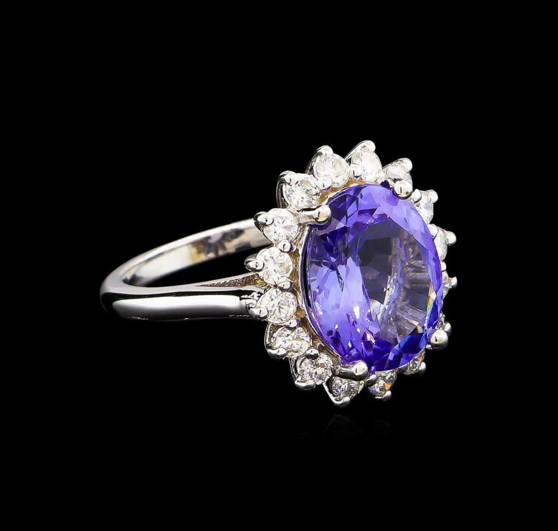 5.67 ctw Tanzanite and Diamond Ring - 14KT White Gold: One electronically tested 14KT white gold lady's cast fashion ring with a basket halo with a bright polish finish. The featured lady's ring has a shank measuring 2.08 millimeters wide. Identified with