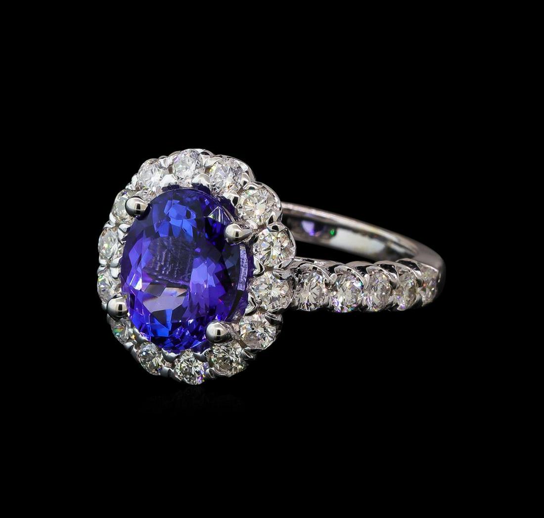 3.27 ctw Tanzanite and Diamond Ring - 14KT White Gold: One electronically tested 14KT white gold lady's cast fashion ring with a scalloped halo with a bright polish finish. The featured lady's ring has a shank measuring 2.23 millimeters wide. Identified w