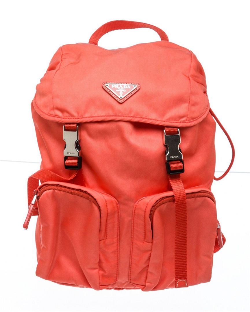 Prada Coral Nylon Buckle Backpack: Prada bright coral nylon backpack with silver-tone hardware, tonal fabric lining, dual front zip pockets, drawstring closure with double buckle flap, top handle, dual adjustable shoulder straps. Measu