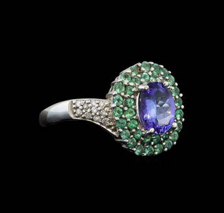 14KT White Gold 1.53 ctw Tanzanite, Emerald and Diamond Ring: One electronically tested 14KT white gold ladies cast tanzanite, emerald and diamond ring with a bright polish finish. Identified with markings of "14K". Condition is new. Containing: One prong set