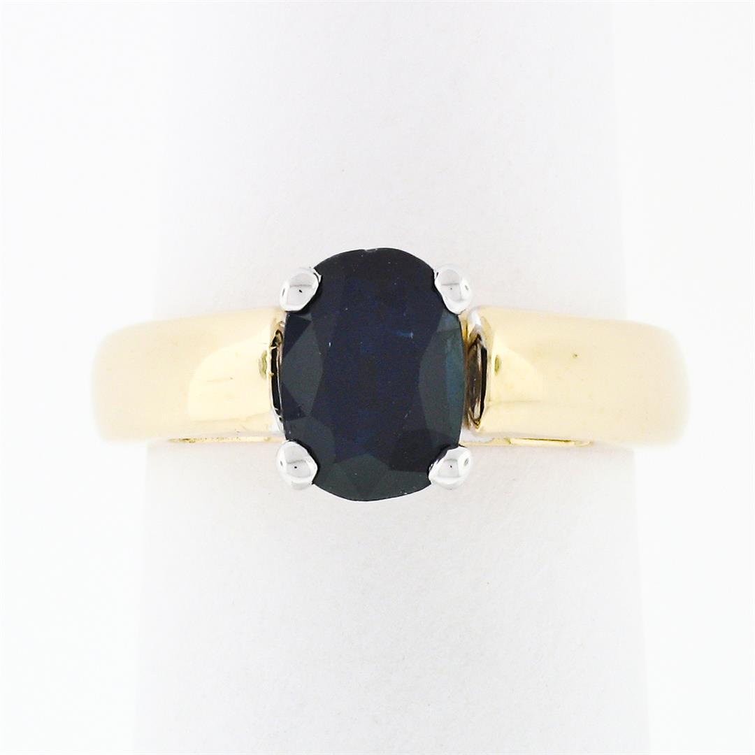 Simple 14k Yellow & White Gold 1.16 ctw Oval Cut Dark Blue Sapphire Solitaire Ri: A solid 14k two tone gold engagement ring with 1 oval cut sapphire solitaire (7x5.15mm - 1.16ct). The ring is size 2.5, weighs a total of 4.28 grams, and measures 7.08mm wide.