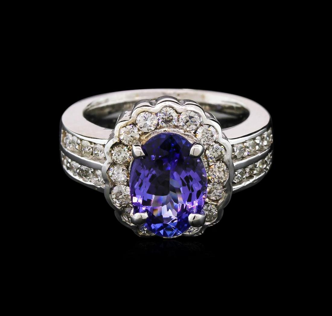 2.77 ctw Tanzanite and Diamond Ring - 14KT White Gold: One electronically tested 14KT white gold lady's cast fashion ring with a bright polish finish. The featured lady's ring has a scalloped halo motif and a shank measuring 4.54 millimeters wide. Identif