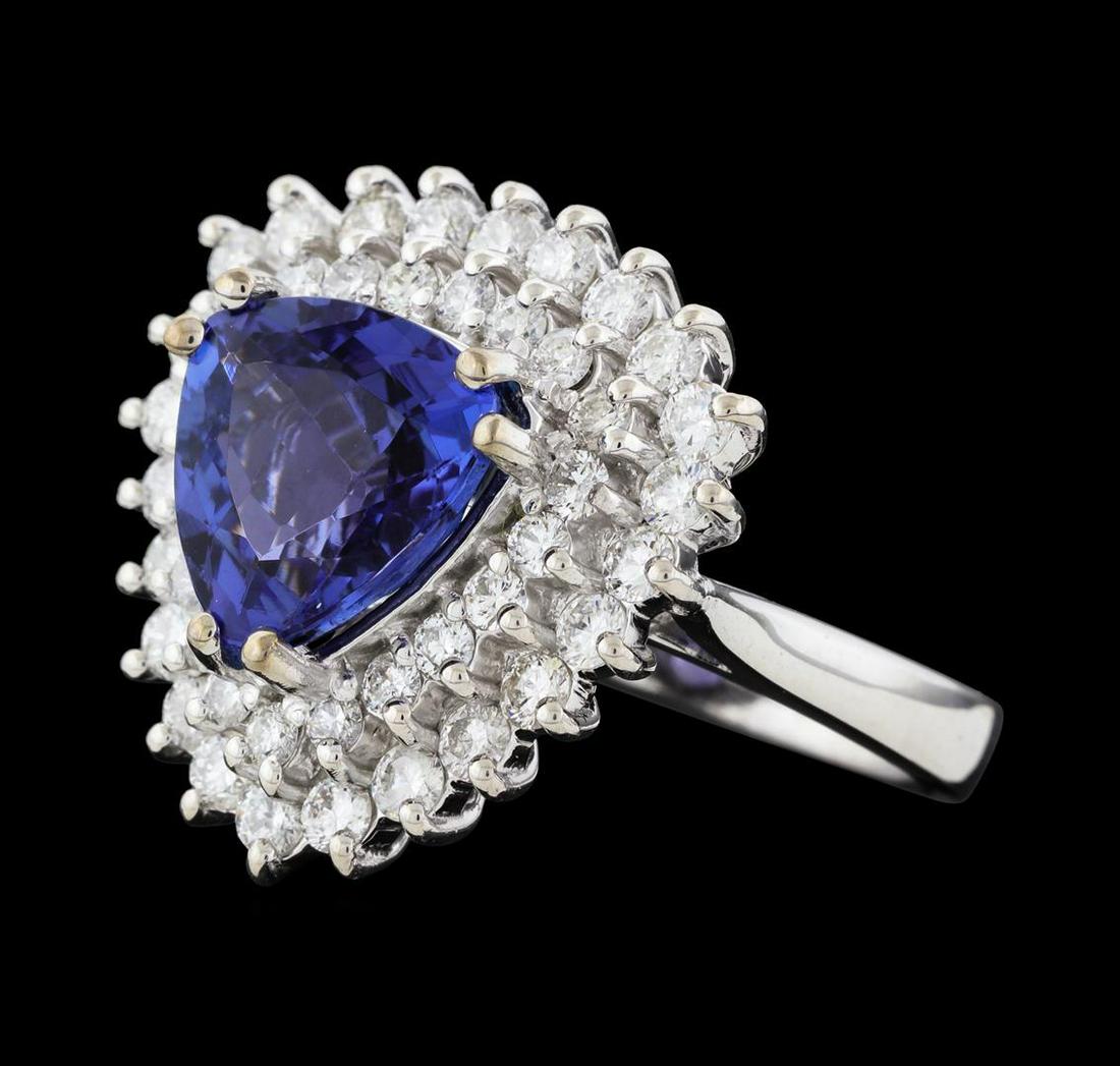 3.62 ctw Tanzanite and Diamond Ring - 14KT White Gold: One electronically tested 14KT white gold lady's cast fashion ring with a double basket halo with a bright polish finish. The featured lady's ring has a shank measuring 2.84 millimeters wide. Identifi