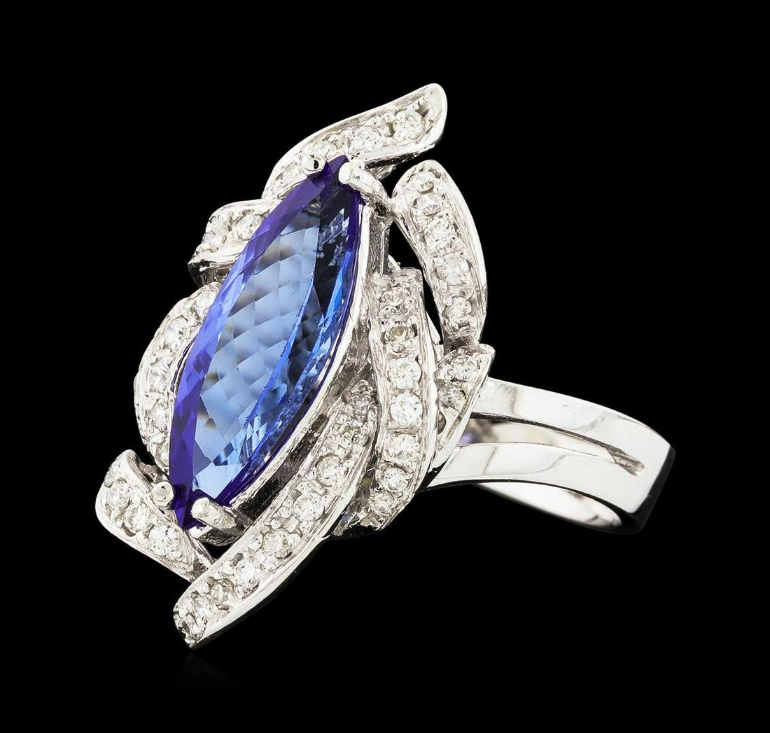 2.29 ctw Tanzanite and Diamond Ring - 14KT White Gold: One electronically tested 14KT white gold lady's cast fashion ring with a swirled basket halo with a bright polish finish. The featured lady's ring has a shank measuring 3.48 millimeters wide. Identif