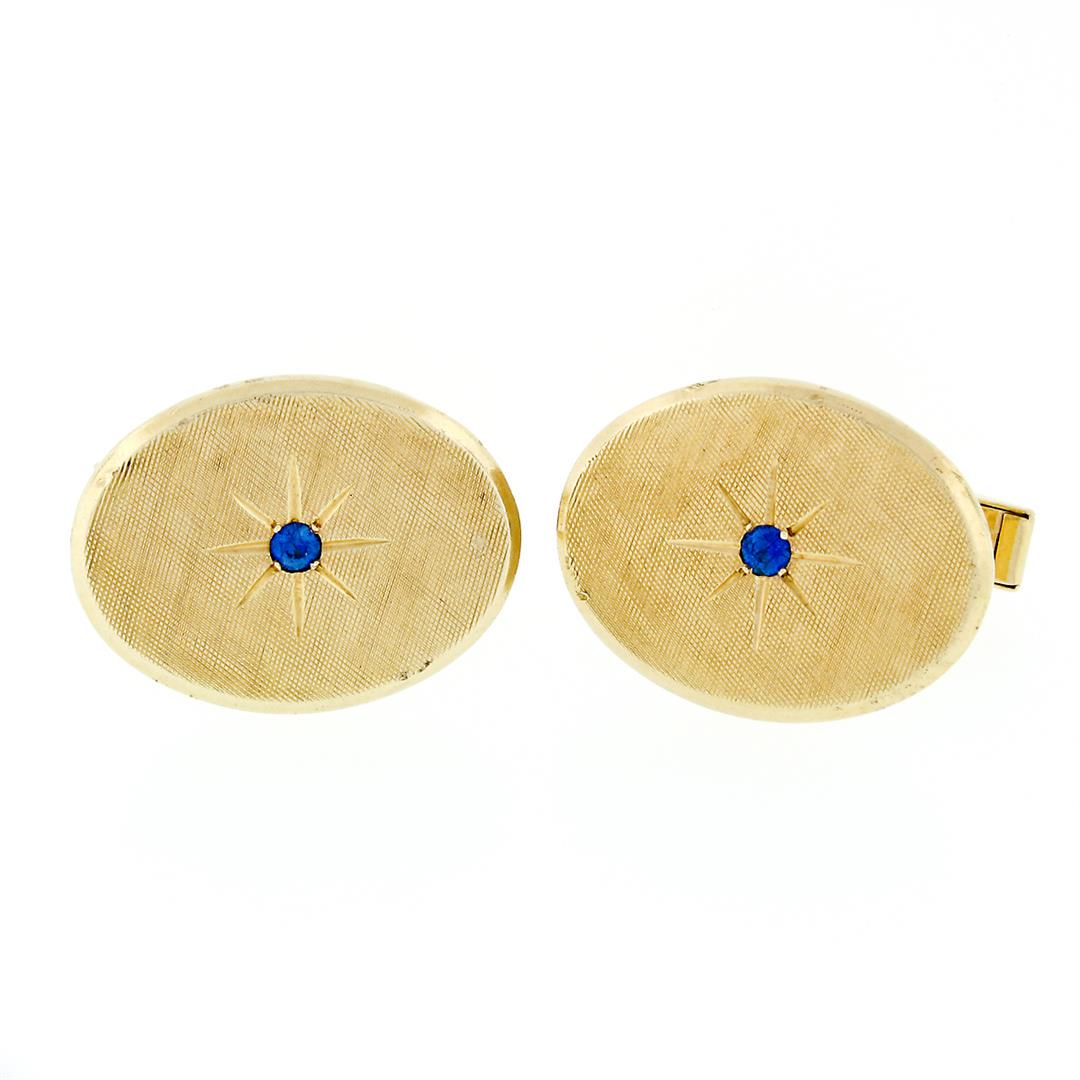 Vintage Tiffany & Co. 14k Gold 0.12 ctw Round Sapphire Oval Florentine Cufflinks: A pair of solid 14k yellow gold cufflinks by Tiffany and Co, with 2 round cut natural sapphires (0.12ctw). These cuff links have swivel design with a clearance of 13.15mm, weigh a total of 12 grams, a