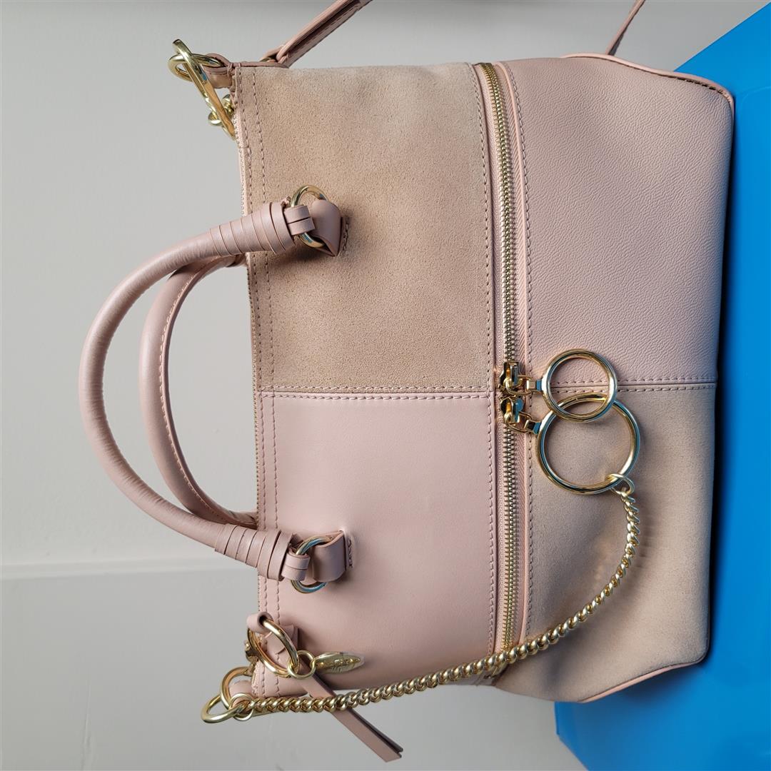 See by Chloe Emy Shoulder Bag - Powder One Size: The See by Chloe Emy Shoulder Bag will complement your everyday style. This bag is made of leather, has a top zip closure, dual rolled top handles, removable and adjustabale shoulder strap, front exte