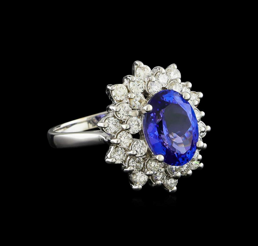 3.50 ctw Tanzanite and Diamond Ring - 14KT White Gold: One electronically tested 14KT white gold lady's cast fashion ring with a double basket halo with a bright polish finish. The featured lady's ring has a shank measuring 2.05 millimeters wide. Identifi