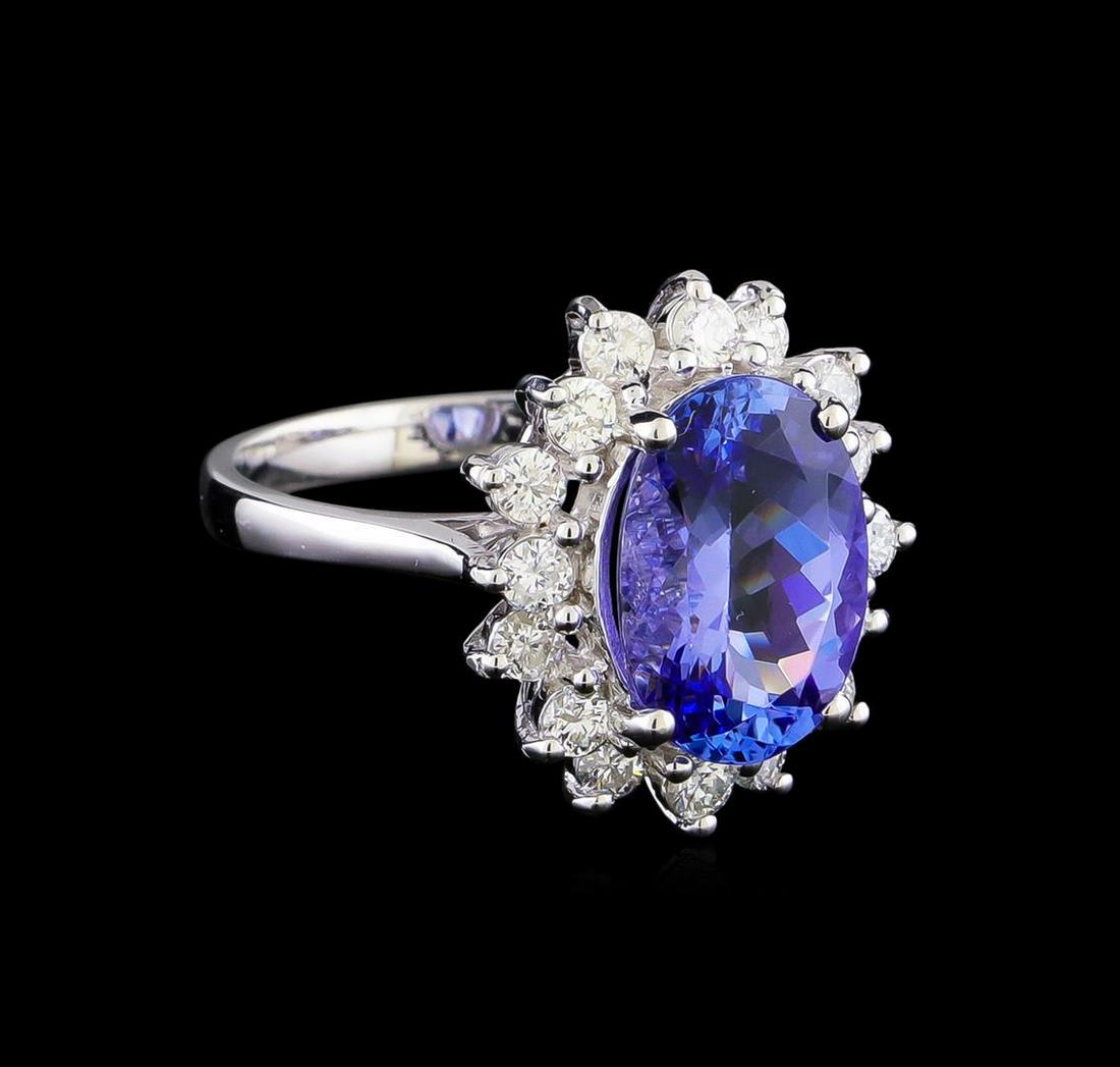 3.88 ctw Tanzanite and Diamond Ring - 14KT White Gold: One electronically tested 14KT white gold lady's cast fashion ring with a basket halo with a bright polish finish. The featured lady's ring has a shank measuring 2.37 millimeters in width. Identified 