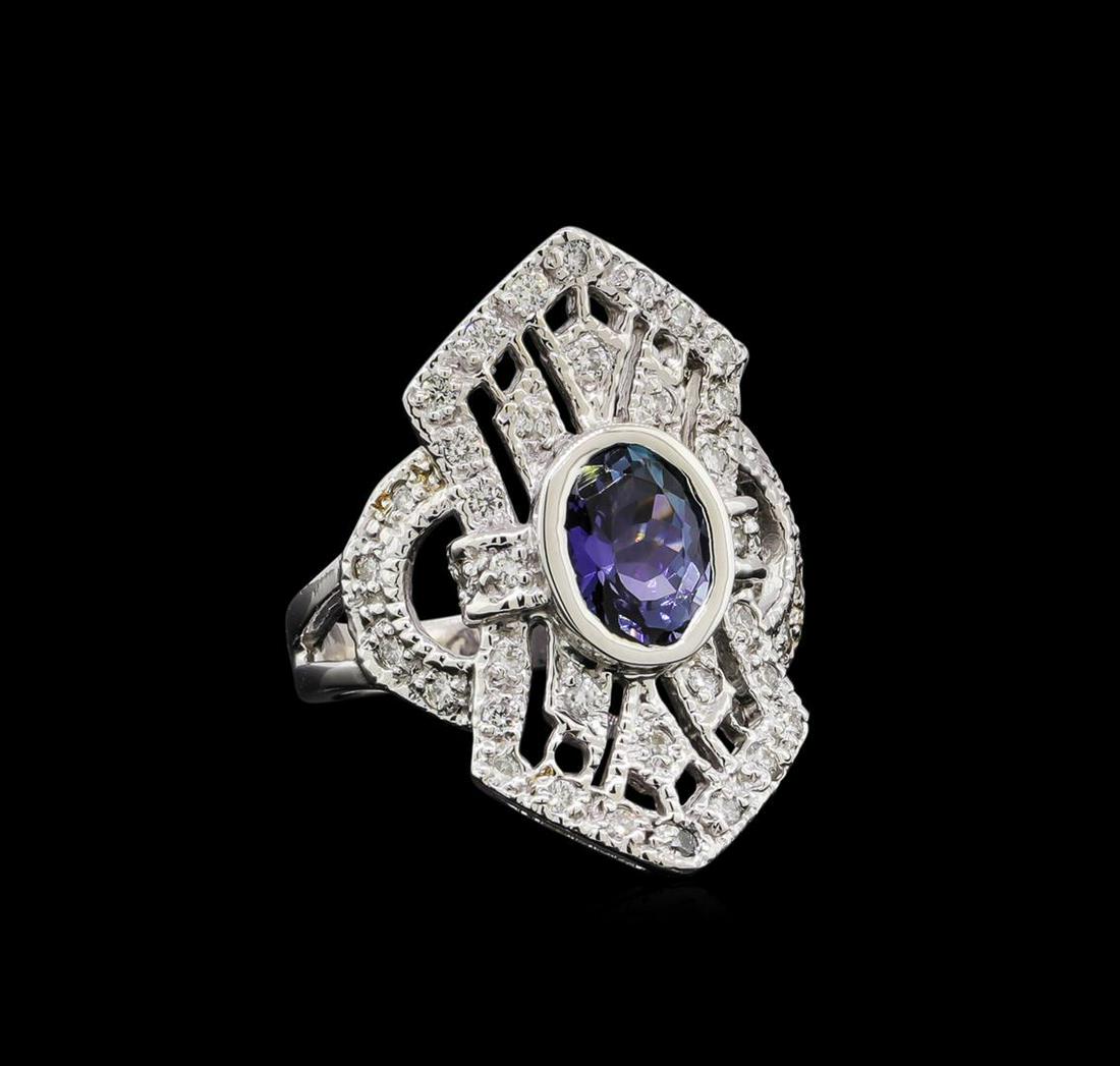 1.84 ctw Tanzanite and Diamond Ring - 14KT White Gold: One electronically tested 14KT white gold lady's cast fashion ring with a vintage with a bright polish with milgrain detailing finish. The featured lady's ring has a shank measuring 2.70 millimeters i