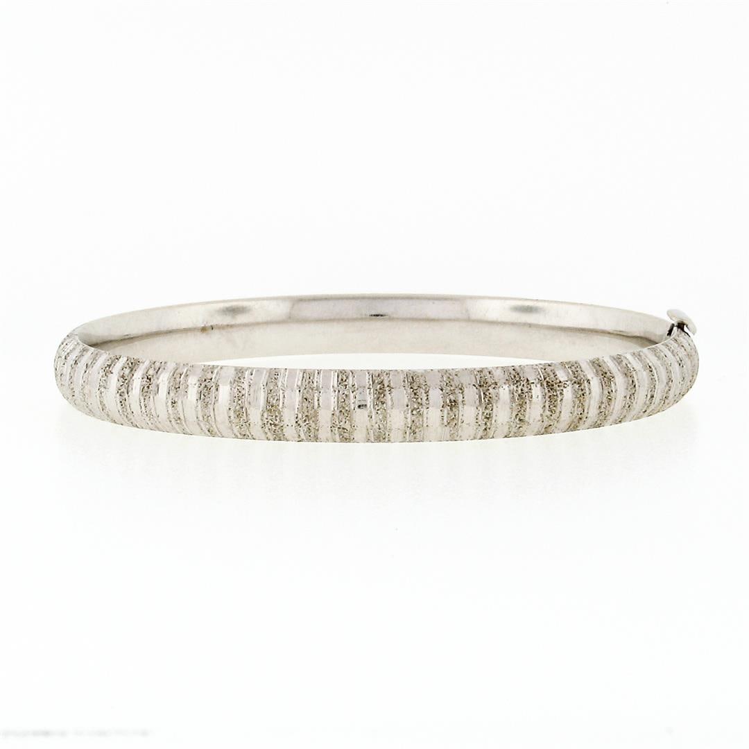 Vintage 14K White Gold Etched Textured Faceted 6.5" Open Slip On Bangle Bracelet: A vintage solid 14k white gold textured hinged open bangle bracelet. It weighs a total of 9.41 grams, measures 63.4mm wide, and measures 6.5 inches in length.