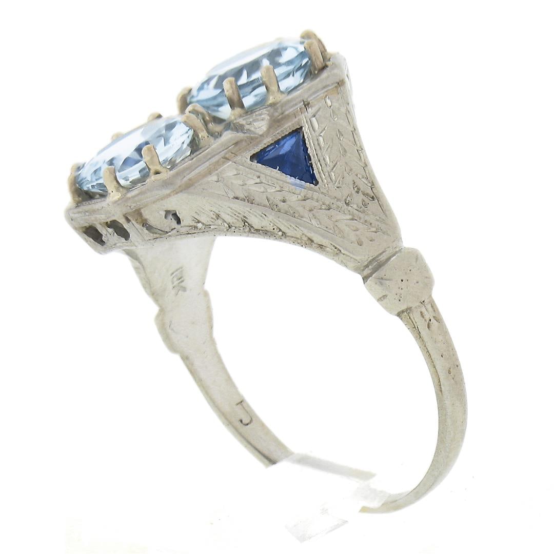 Antique Art Deco 18K Gold Moi et Toi Aquamarine & Sapphire Wheat Engraved Ring: An antique solid 18k white gold ring, with 2 round cut natural aquamarines (6.5mm - 1.62ctw), and 2 French trillion cut synthetic sapphires (3.3mm ). The ring is size 7.0, weighs a total of 4.35 grams