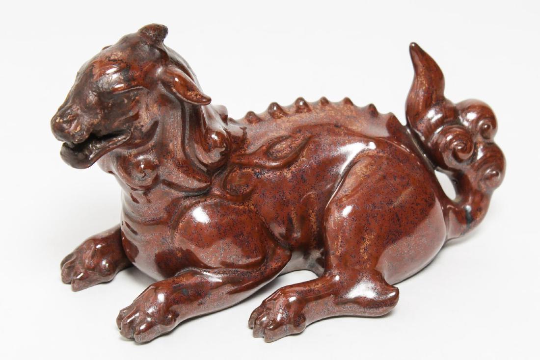 Asian Earthenware Pottery Dragon: Asian earthenware pottery dragon, possibly Chinese, recumbent pose in red glaze bearing two incised characters on underside. 5" H X 7.5" L.