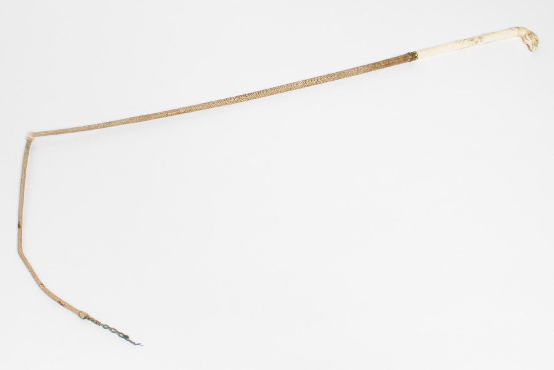 Antique Bone, Brass & Leather Ram's Head Quirt: Equestrian; Antique bone and braided leather quirt or riding whip with brass collar, the bone handle carved with ram's head end, and shaft with twining grape vine. Overall: 31" L. Minor age crack to h
