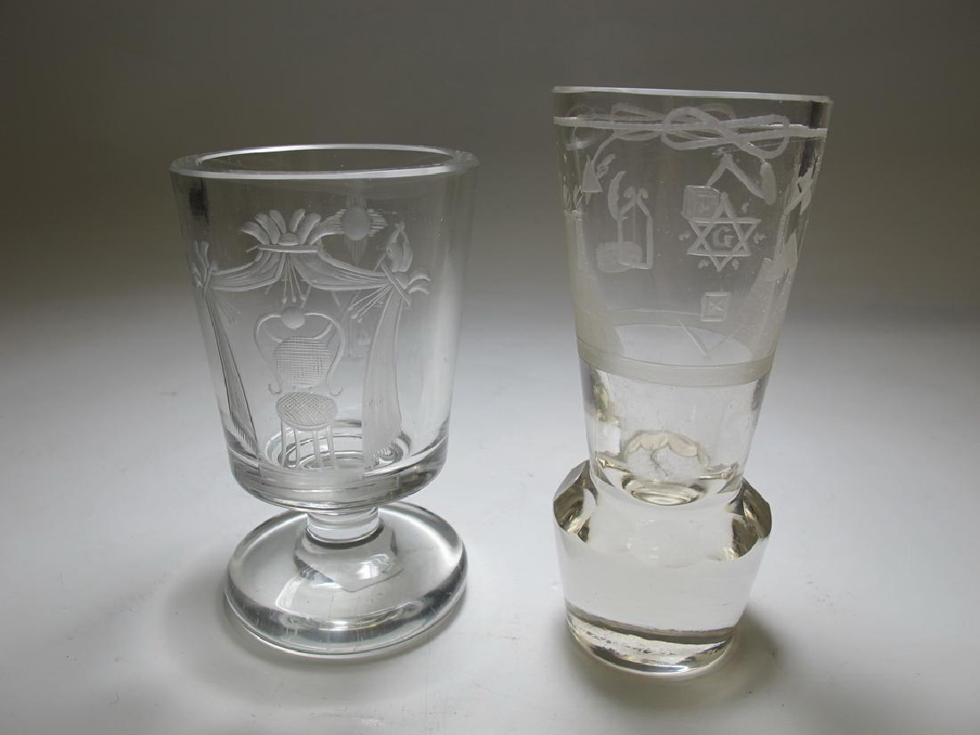 2 Masonic Bohemian firing & wine glasses: Lot of two pieces. One Bohemian firing cannon engraved with Masonic symbols and heavy round base. One wine glass engraved bowl with Masonic symbols, plain short stem upon circular base. 5 1/8" H x 2 1