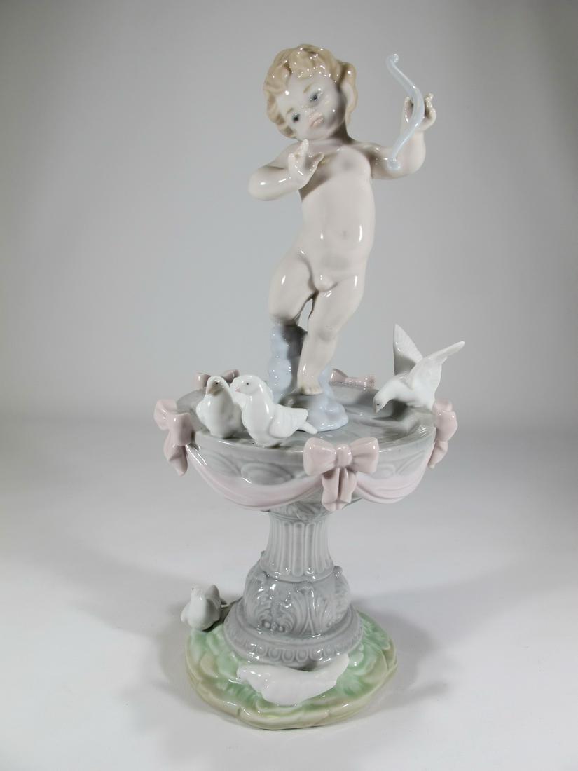 Retired Lladro Fountain of Love porcelain statue: Retired Lladro Fountain of Love porcelain statue. Sculptor: Juan Ignacio Aliena. It was issued in 1998 and retired in 2007. 11” H x 5 1/8” W x 5” D. Shipping in USA or International 