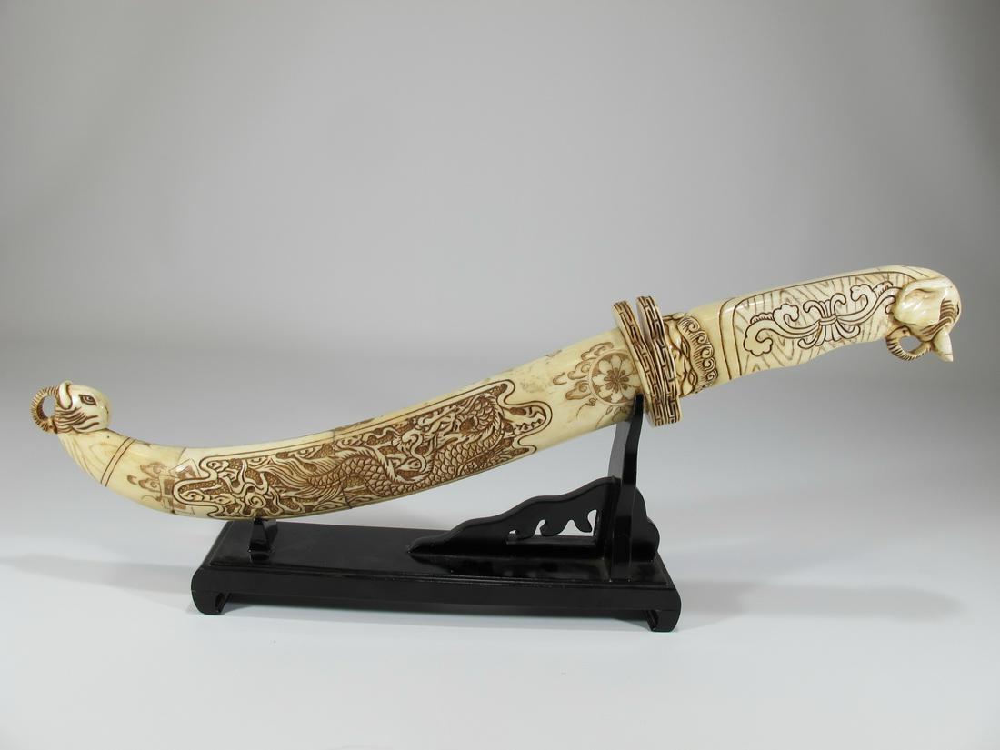 Vintage Chinese hand carved bone sword with stand: Vintage Chinese hand carved bone sword with stand. Sword: 15 3/4” long x 2 1/4” W x 1 5/8” D. Stand; 4 1/8” H x 8 1/4” W x 2” D. Shipping in USA or International pl