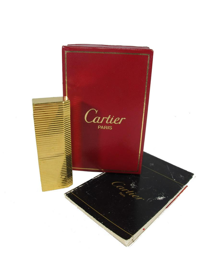 Cartier Paris gold plated lighter in a box: Cartier Paris gold plated lighter in a box. Box: 1 1/4” H x 4” W x 2 1/2” D. Lighter: 2 3/4” H x 1” W x 1 1/2” D. ANY INVOICE OVER $ 2,000.00 WE WILL ACCEPT PAYMENT