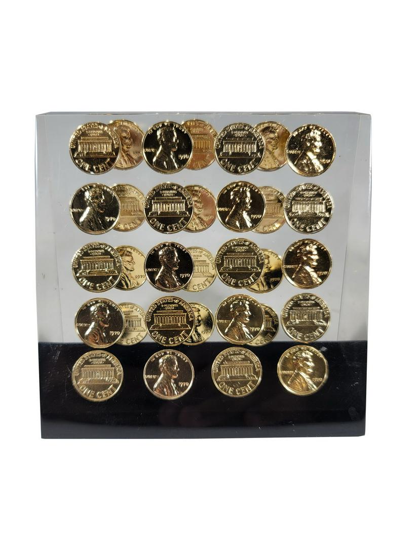 Gilt USA cents inside a lucite paperweight: Gilt USA cents inside a lucite paperweight. 4 3/8” H x 4 5/8” W x 2 5/8” D. ANY INVOICE OVER $ 2,000.00 WE WILL ACCEPT PAYMENTS ONLY THROUGH CHECK OR BANK WIRE TRANSFER, SAME FOR INT