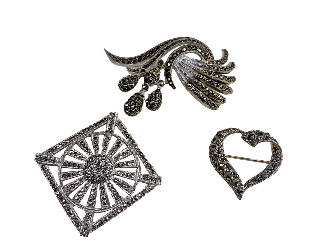 3 Sterling 925 & Marcasite Brooches: 3 Sterling 925 & Marcasite Brooches. Heart: 1 x 1 in. Square: 1 1/4 x 1 1/4 in. German: 2 x 1 1/4 in. Weight: 32.8 grams.Local Pick up call one day before to make an appointment. TO SHIP THIS ITEM IN 