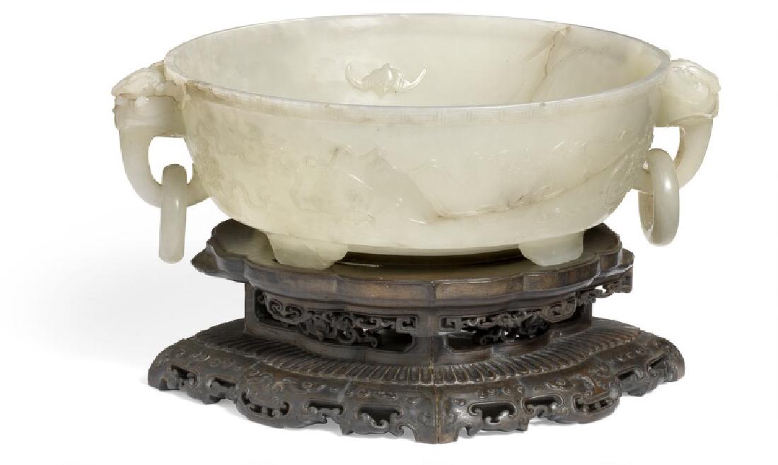 A Chinese mutton fat jade bowl interior with flowers,: A Chinese mutton fat jade bowl interior with flowers, bats and lingzhi fungus in relief, dragon handles with pendant ring. Exterior with Buddhist symbols in relief and a la Grecque trimming. Bottom ca