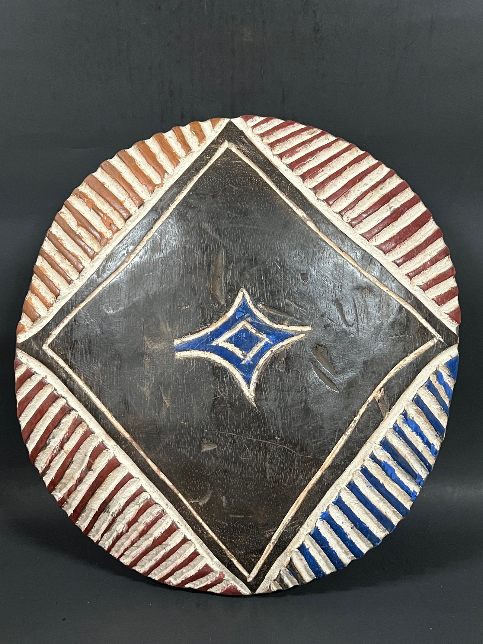 Zulu Shield: African Tribal Art Zulu Shield. The dimension is 14.5 inches high x 13.5 inches wide. Please be aware that some of the items are vintage, secondhand, old ages, antiques and may have a defects or sign