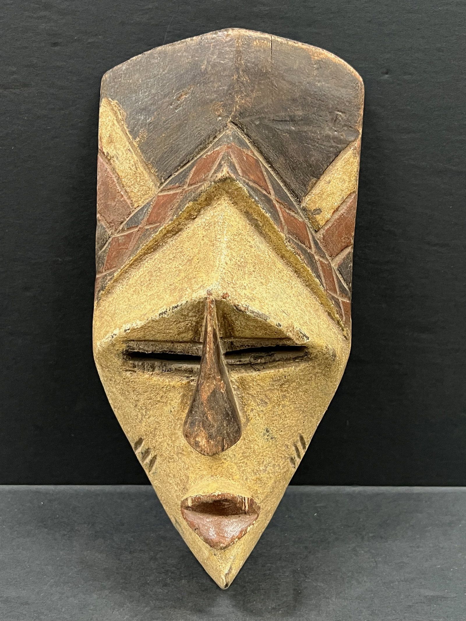 Tikar Mask: African Tribal Art Tikar Mask. The dimension is 11 inches high x 5.25 inches wide. Please be aware that some of the items are vintage, secondhand, old ages, antiques and may have a defects or sign of