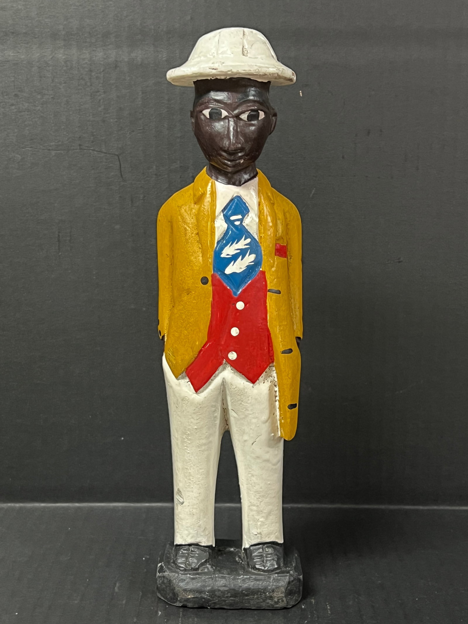 Colonial Statue: African Tribal Art Colonial Statue. The dimension is 12 inches high x 3 inches wide. Please be aware that some of the items are vintage, secondhand, old ages, antiques and may have a defects or sign
