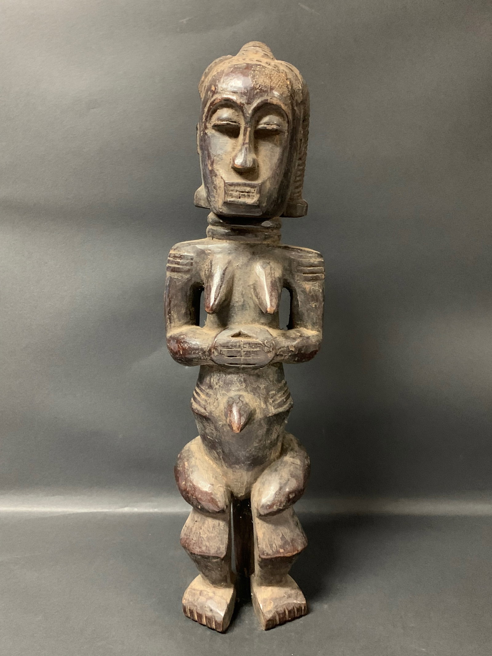 Carved Wood Fang Statue: African Tribal Art Carved Wood Fang Statue. The dimension is 19.5 inches high x 6 inches wide. Please be aware that some of the items are vintage, secondhand, old ages, antiques and may have a defects