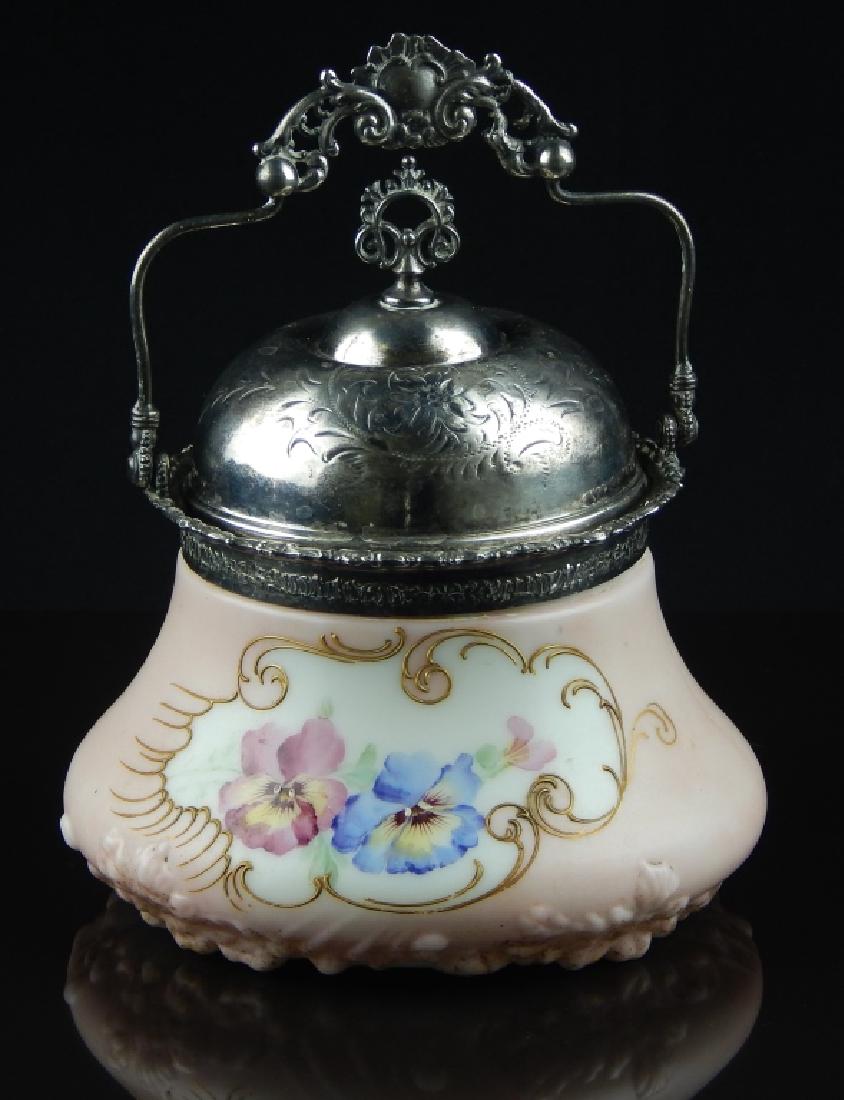 ANTIQUE PAIRPOINT SILVER AND PORCELAIN BISCUIT BOX: Antique satin porcelain biscuit box with painted floral design and engraved silver lid with ornate handle. Marked to bottom. Measures approx 8" height by 7 1/2" diameter.