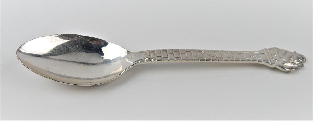 TIFFANY & CO STERLING SILVER SANTA CLAUS SPOON: Enchanting spoon crafted of sterling silver by Tiffany & Company having a Christmas motif depicting Santa Claus with his bag of toys atop a brick chimney with stocking on handle. Verso of handle show 