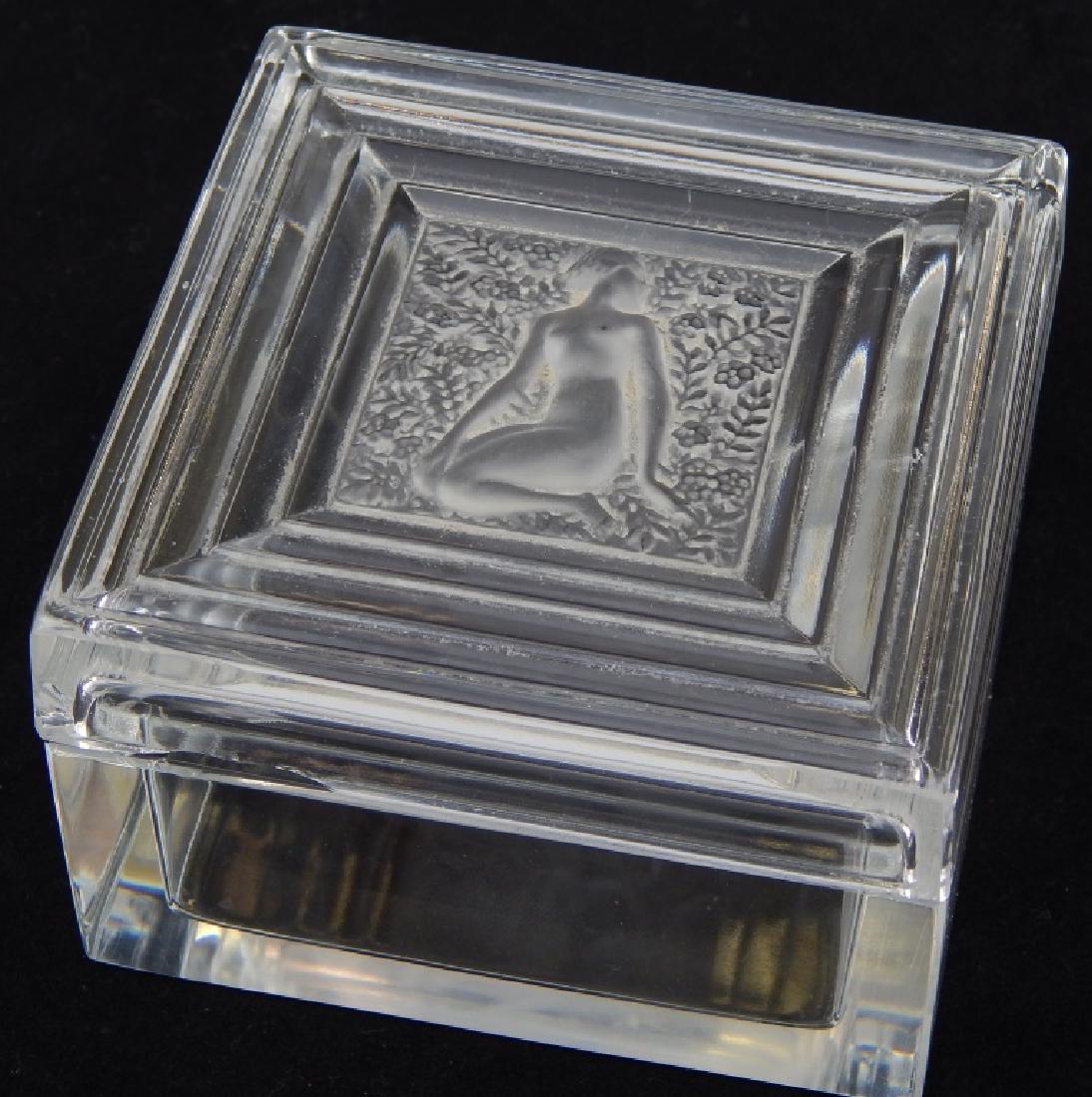 LALIQUE FRANCE "DUNCAN" NUDE SQUARE COVERED BOX: Lalique French crystal "Duncan" covered box of square form with center medallion depicting a seated nude female. Etched script "Lalique France" mark to bottom. Measures approx. 2 1/2" tall x 3 3/4" wi
