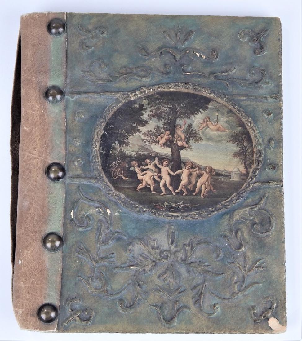 ANTIQUE PAPIER MACHE LEATHER STUDDED BOOK BINDING: Antique European book binding cover crafted of papier mache hard cover back with raised scrollwork. Center with classical cherubs scene in oval cartouche. Leather binding with metal studs. Measures ap