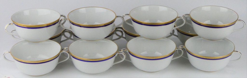 12 RICHARD GINORI GILT RIM CREAM SOUP BOWLS CUPS: A set of 12 Italian porcelain cream soup cup / bowls with 2 handles by Richard Ginori. Has an inverted "C" design to rim in gold accented with a royal blue band. Bowls measure approx. 2 1/8" tall x 5 