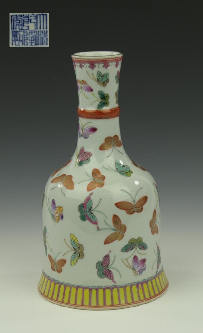 CHINESE FAMILLE ROSE BUTTERFLIES MALLET VASE: Chinese hand painted Famille Rose enameled vase of mallet or bell form depicting flying butterflies throughout. Some butterflies painted in iron red and gold colors while others have thicker enamel mu