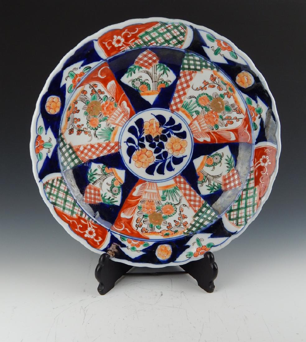 JAPANESE IMARI IRON RED & COBALT FLORAL CHARGER: A vintage possibly antique? Japanese Imari porcelain scalloped rim charger having hand painted floral designs throughout with heavy iron red and cobalt blue grounds. Measures approx. 15 3/4" diameter 