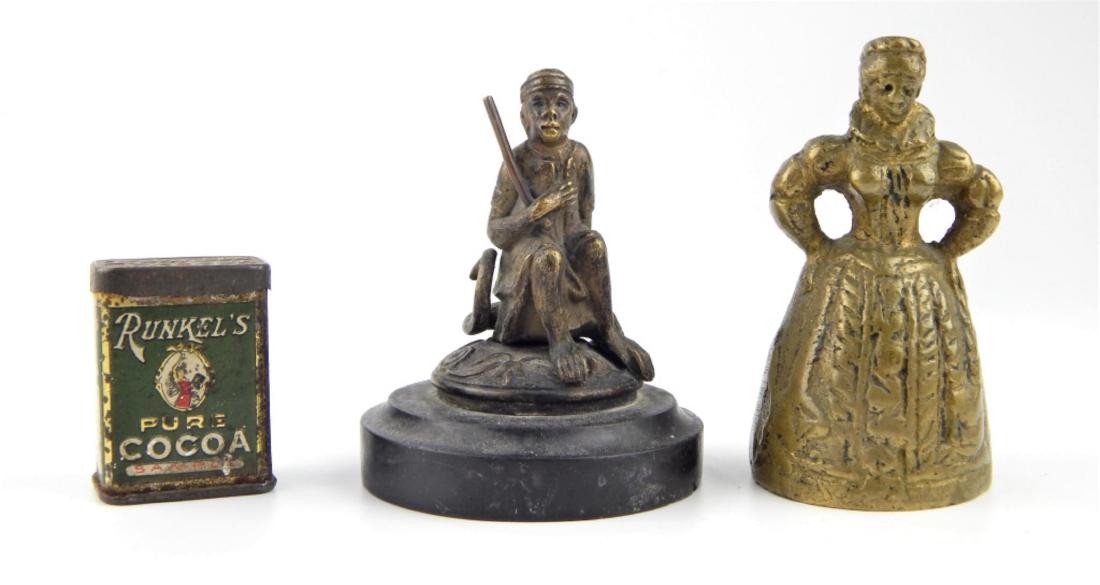 LOT OF 3 INTERESTING VINTAGE METALWARE CURIO ITEMS: A lot of 3 vintage metal ware items to include a, what appears to be Thai seated monkey on black stone base, brass figural table bell and a tin Rinkel's, New York pure cocoa sample box. Tallest approx