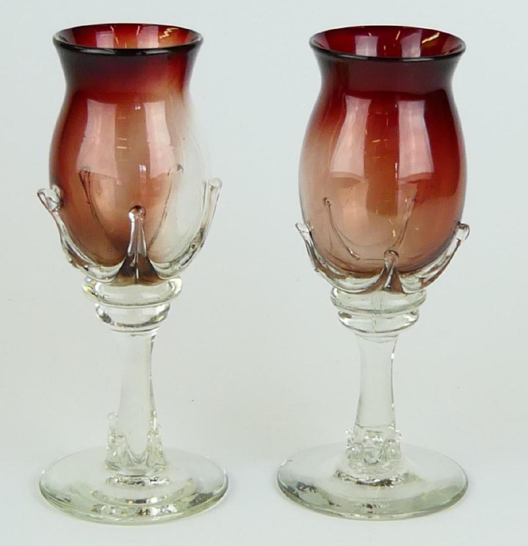 Pr ROBERT DEEBLE STUDIO RUBY GLASS WINE GOBLETS: A pair of Robert Deeble, Middlebury, Vermont hand blown ruby and clear art glass wine goblet stem glasses. Each with etched signature to bottom. Glasses measure approx. 9" height x 4" diameter (22.8cm