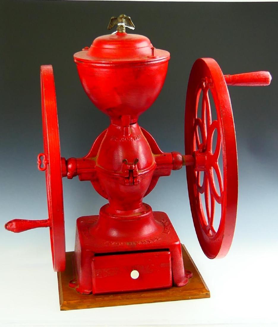 ANTIQUE ENTERPRISE MFG Co PHILA IRON COFFEE MILL: Antique Enterprise Manufacturing Company Philadelphia, Pennsylvania iron two wheel coffee mill with eagle finial. Completed with red paint throughout. Has a patent dated of July 12, 1898. Measures app